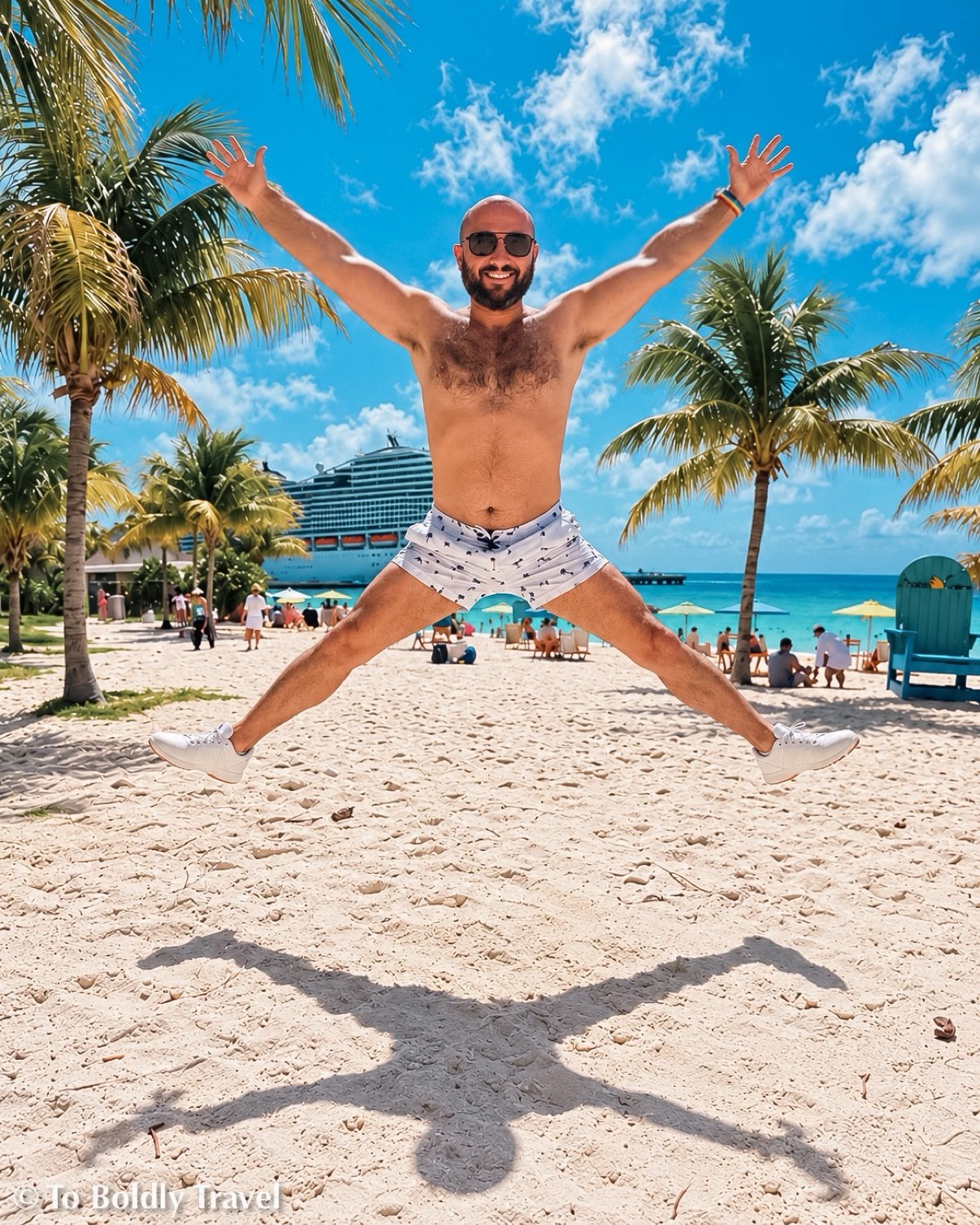Michel star-jumping on the sand, palms and lifeguard stand